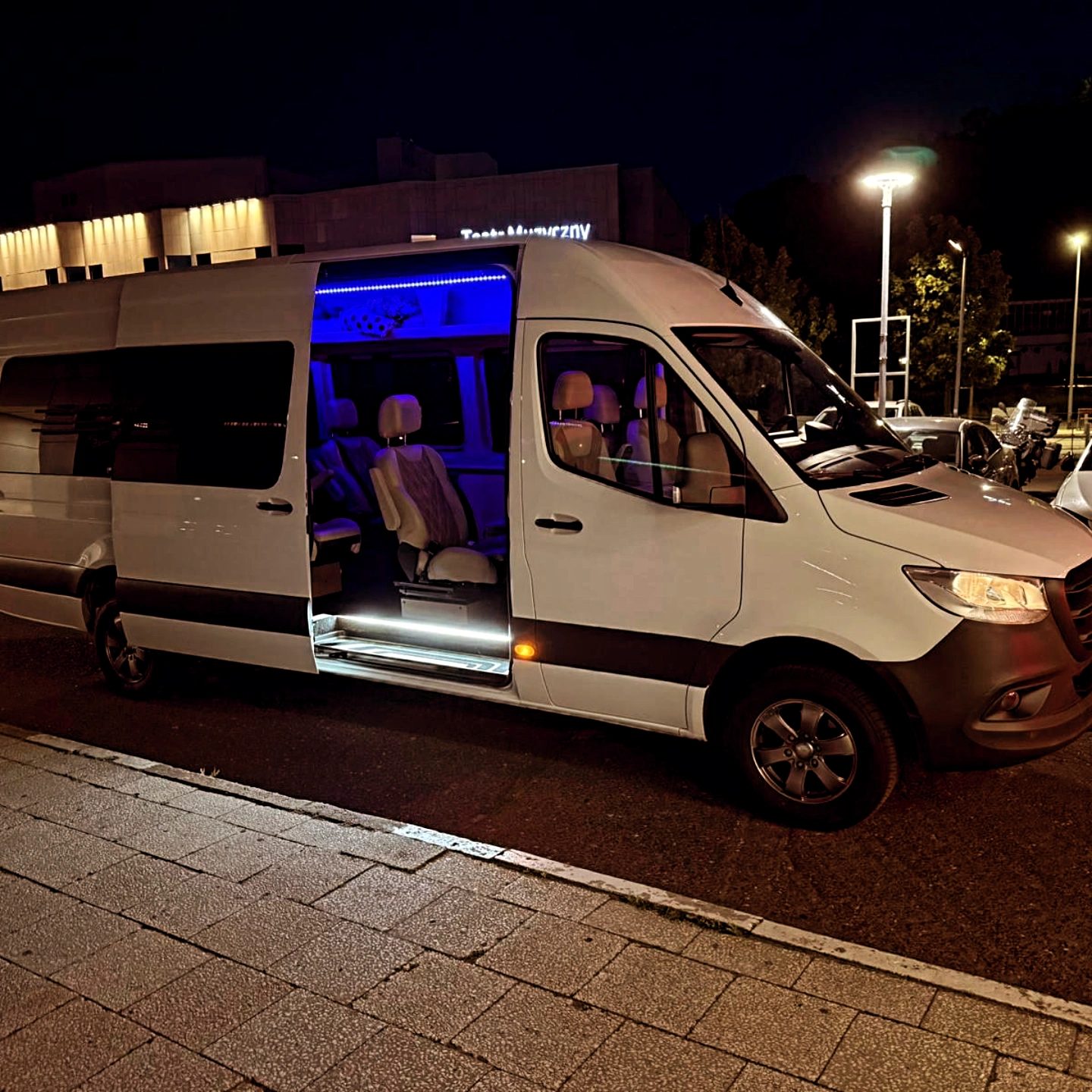 Bus premium Mercedes-Benz Sprinter nocą pod Teatrem Muzycznym