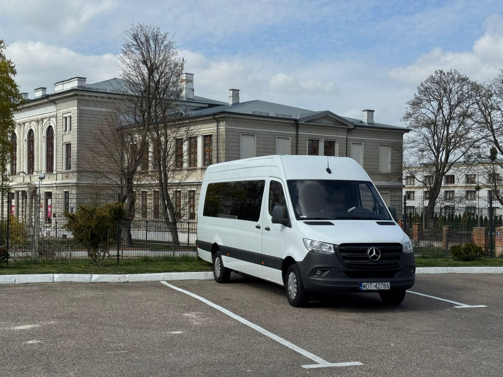 Bus Mercedes-Benz Sprinter na przejeździe krajowym — postój przy pałacu