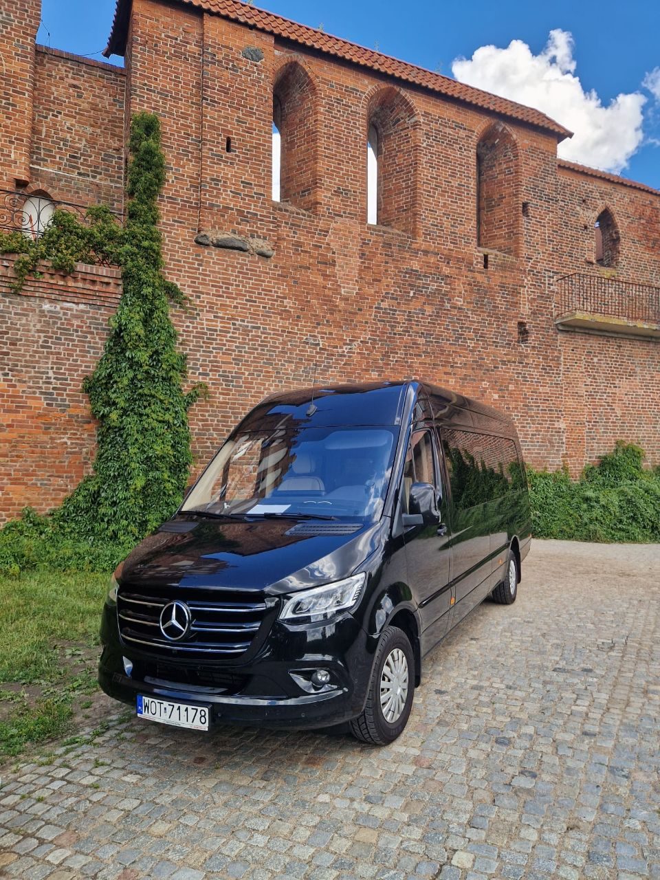 Czarny Mercedes-Benz Sprinter przy murach zamkowych — wycieczka premium